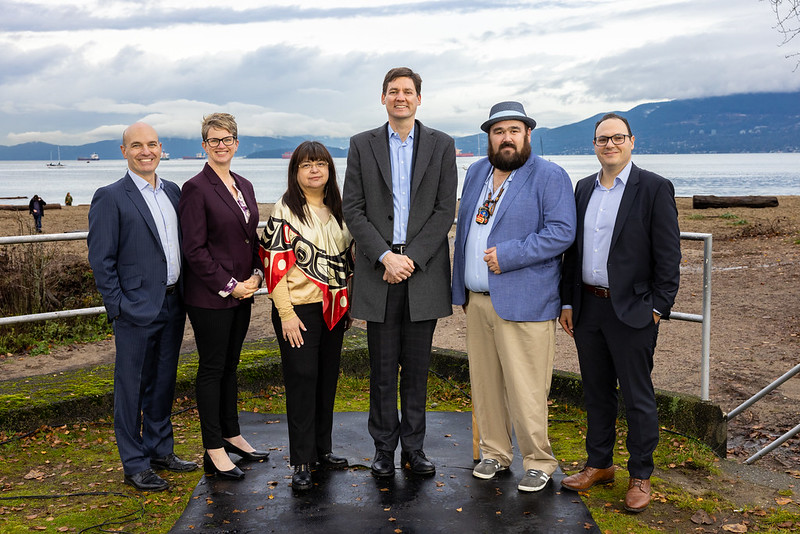 From left to right: Nathan Cullen, Minister of Water, Land and Resource Stewardship; Jennifer Rice, Parliamentary Secretary for Rural Health; K̓áwáziɫ Marilyn Slett, Chief Councillor of the Heiltsuk Nation and President of Coastal First Nations; Premier David Eby; Dallas Smith, President of Nanwakolas Council; and Eddy Adra, CEO of Coast Funds at the funding announcement in Vancouver.