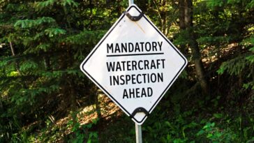 A road sign reading "mandatory watercraft inspection ahead"