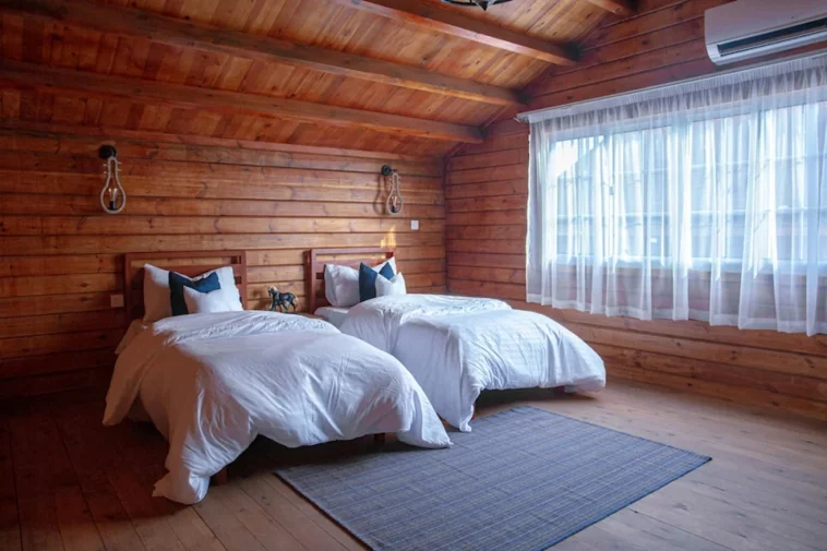 wooden bed and breakfast room with two large beds next to a window